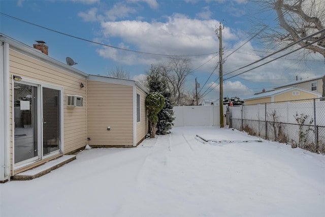 yard layered in snow featuring an AC wall unit