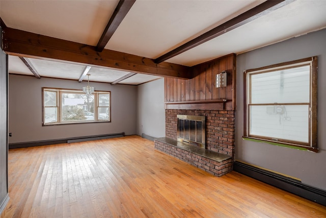 unfurnished living room featuring beamed ceiling, a baseboard radiator, a fireplace, and light hardwood / wood-style flooring