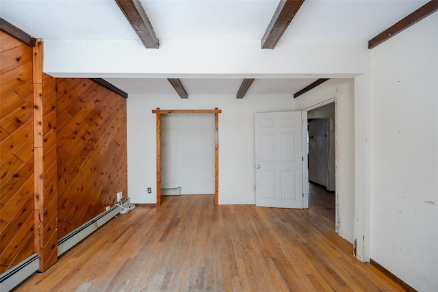 unfurnished bedroom featuring a baseboard radiator and beam ceiling