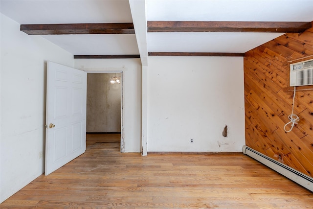 empty room with an AC wall unit, wooden walls, beamed ceiling, a baseboard radiator, and light wood-type flooring