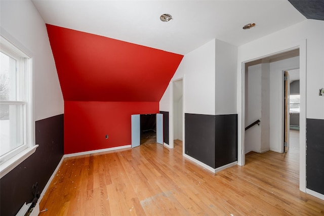 bonus room with vaulted ceiling and light hardwood / wood-style floors