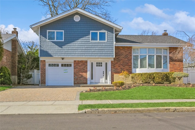 tri-level home with a garage and a front yard