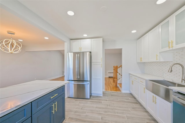 kitchen featuring blue cabinetry, tasteful backsplash, hanging light fixtures, stainless steel appliances, and white cabinets