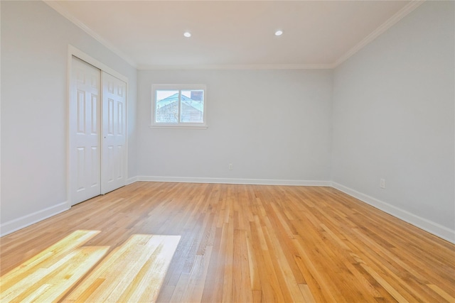 empty room with ornamental molding and light hardwood / wood-style floors