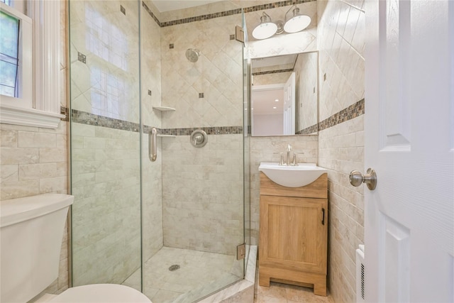 bathroom featuring tile walls, an enclosed shower, vanity, and toilet