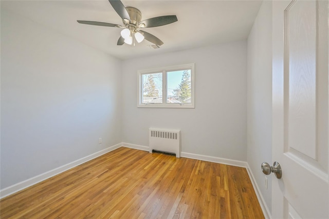 spare room featuring light hardwood / wood-style flooring, radiator heating unit, and ceiling fan