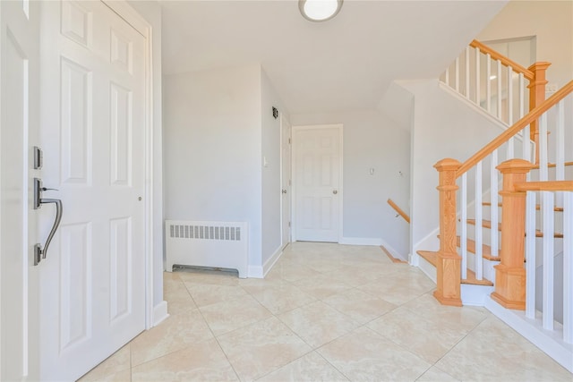 foyer entrance featuring radiator and light tile patterned floors