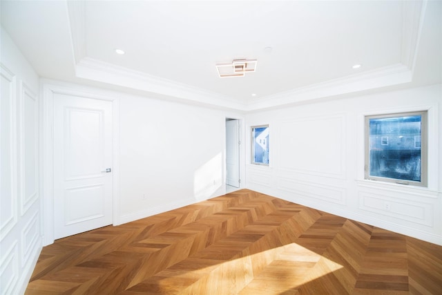 empty room featuring ornamental molding, parquet floors, and a tray ceiling