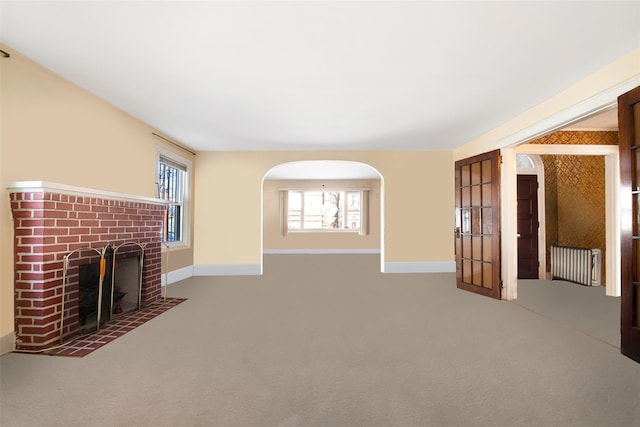 unfurnished living room with a fireplace and carpet flooring