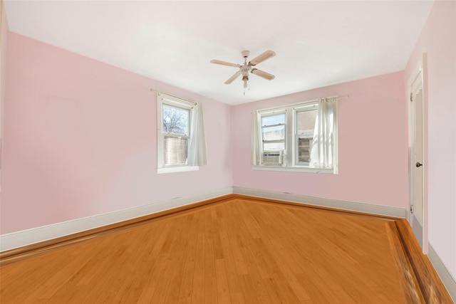 spare room featuring cooling unit, wood-type flooring, and ceiling fan