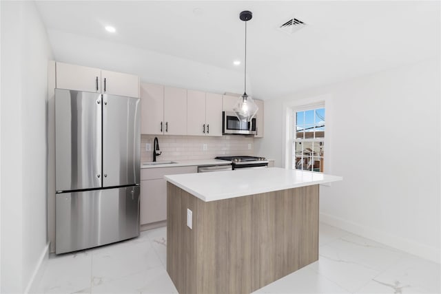 kitchen featuring pendant lighting, sink, appliances with stainless steel finishes, a kitchen island, and decorative backsplash