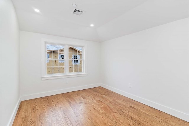 unfurnished room featuring hardwood / wood-style flooring and vaulted ceiling