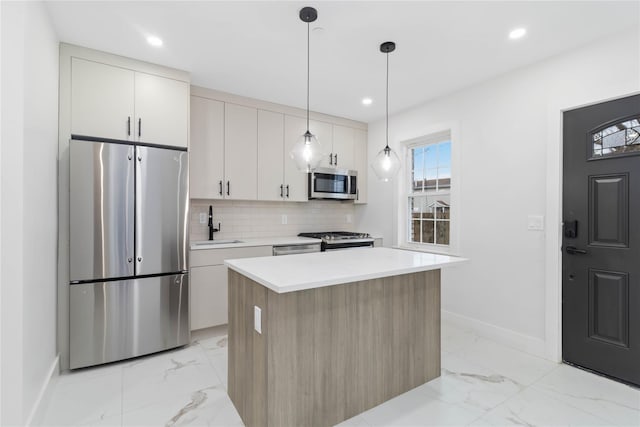 kitchen featuring a center island, hanging light fixtures, stainless steel appliances, decorative backsplash, and white cabinets