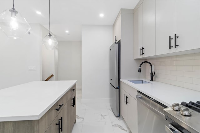 kitchen featuring sink, white cabinetry, tasteful backsplash, pendant lighting, and stainless steel appliances