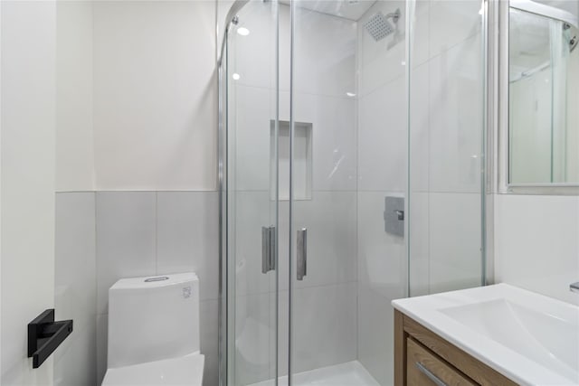 bathroom featuring vanity, a shower with door, and toilet