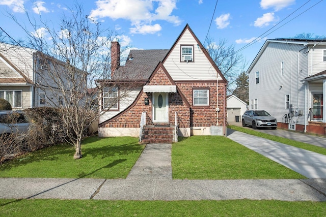 tudor-style house with an outbuilding, a garage, and a front yard