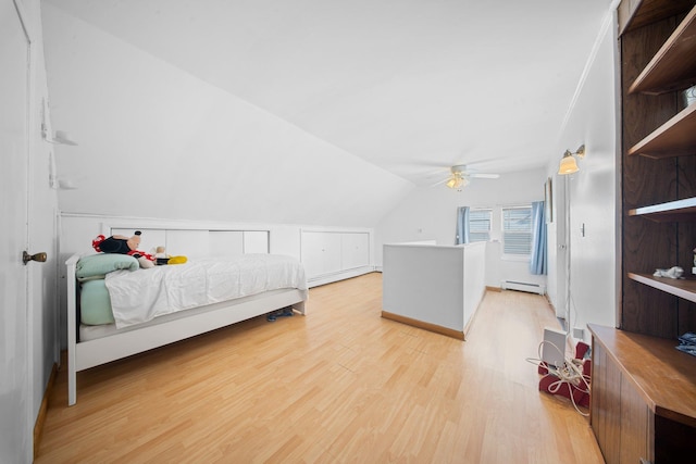 bedroom with light hardwood / wood-style flooring, a baseboard radiator, ceiling fan, and vaulted ceiling