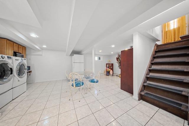 washroom featuring separate washer and dryer, light tile patterned floors, and cabinets