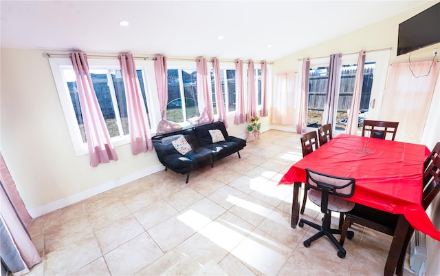 tiled dining room with lofted ceiling and a wealth of natural light