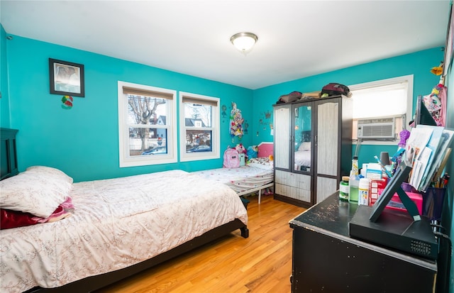 bedroom with hardwood / wood-style flooring and cooling unit