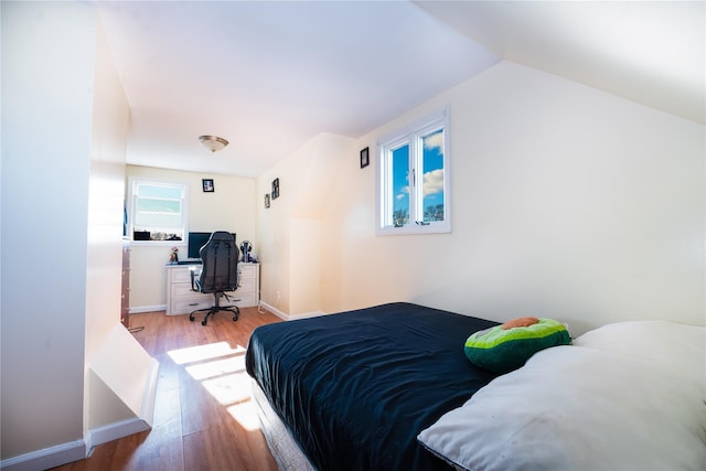 bedroom featuring vaulted ceiling and light hardwood / wood-style flooring