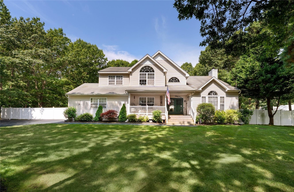 view of front of home with covered porch and a front lawn