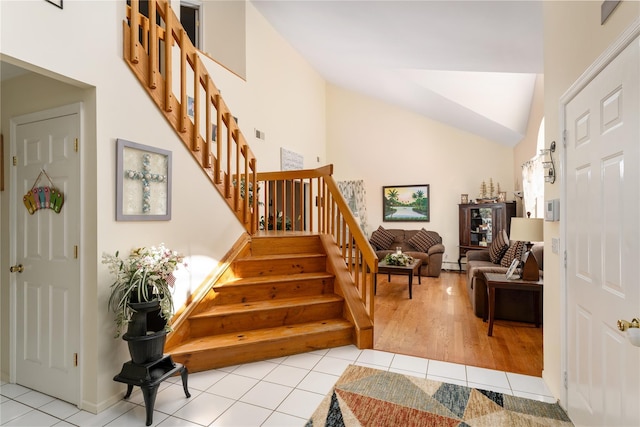 staircase featuring tile patterned flooring and lofted ceiling