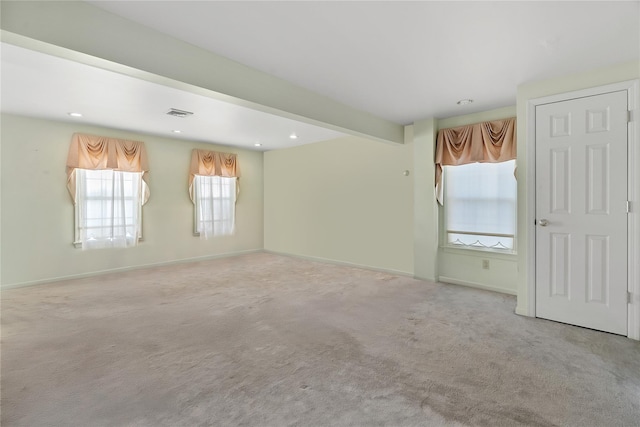 carpeted empty room with beamed ceiling