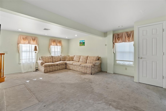 carpeted living room featuring beam ceiling