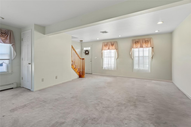 unfurnished living room featuring a baseboard heating unit and light colored carpet