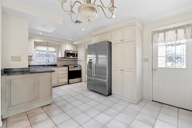 kitchen featuring sink, light tile patterned floors, backsplash, hanging light fixtures, and stainless steel appliances