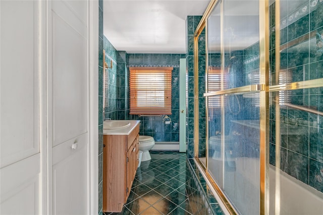 bathroom with tile walls, tile patterned flooring, vanity, a shower with shower door, and toilet