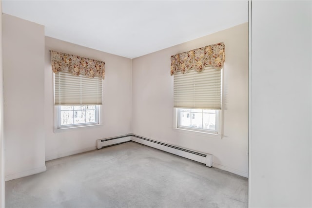 carpeted spare room with a baseboard heating unit