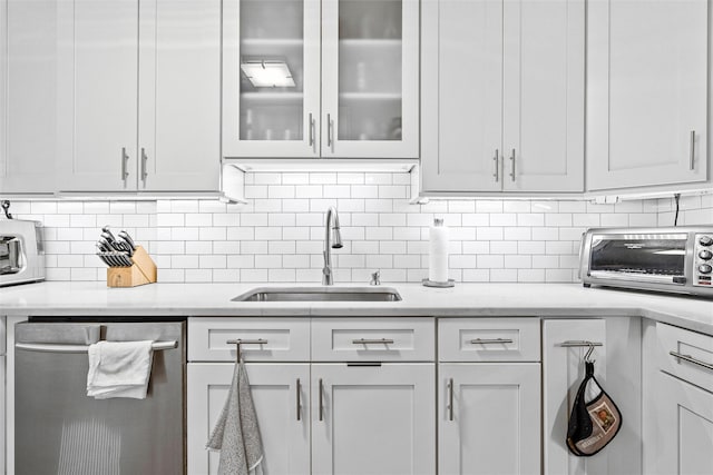 kitchen featuring white cabinetry, sink, tasteful backsplash, and stainless steel dishwasher