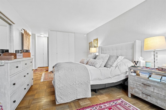 bedroom featuring parquet floors and a closet