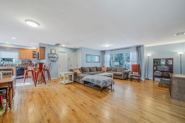 living room with beverage cooler and light hardwood / wood-style floors