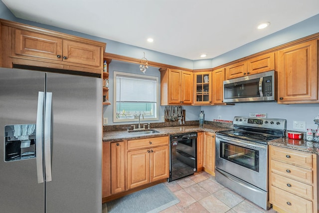 kitchen featuring appliances with stainless steel finishes, sink, dark stone countertops, and light tile patterned floors