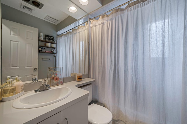 bathroom featuring vanity, curtained shower, and toilet