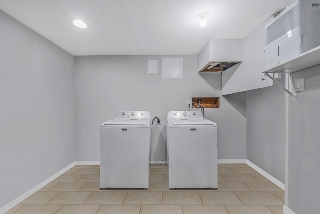 clothes washing area with light tile patterned flooring and washer and clothes dryer