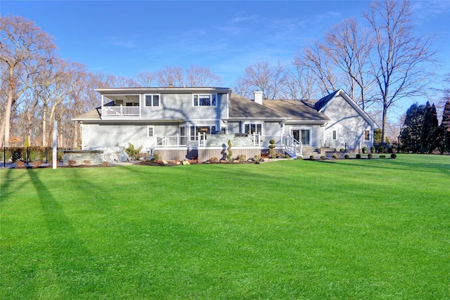 rear view of house with a lawn and a deck