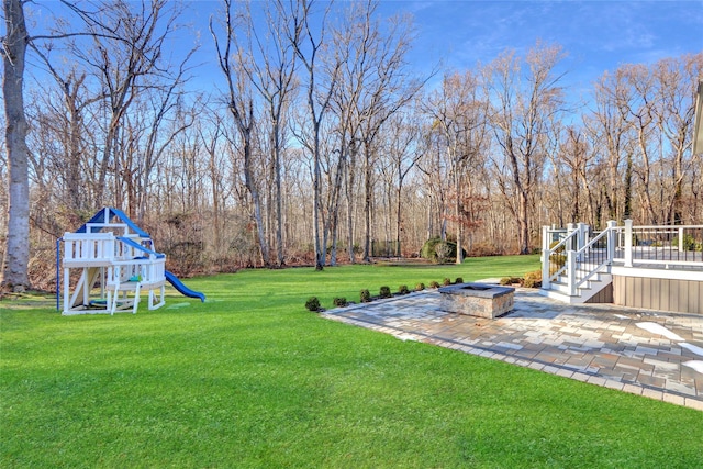 view of yard featuring a playground and a patio area