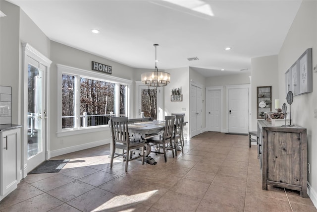 dining space featuring light tile patterned flooring and a chandelier