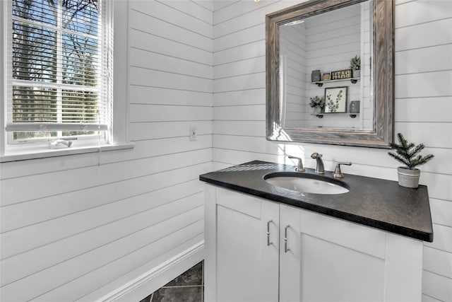 bathroom with vanity and wooden walls