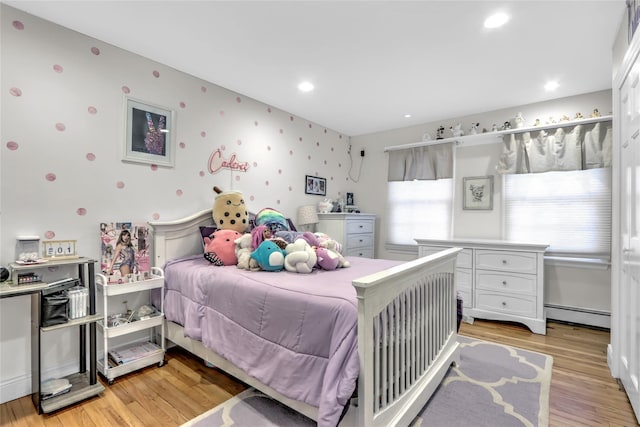 bedroom featuring a baseboard radiator and light hardwood / wood-style floors