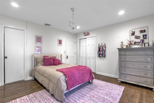 bedroom with dark wood-type flooring, a closet, and a notable chandelier