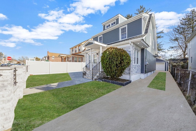 view of front of home featuring an outbuilding, a garage, and a front yard