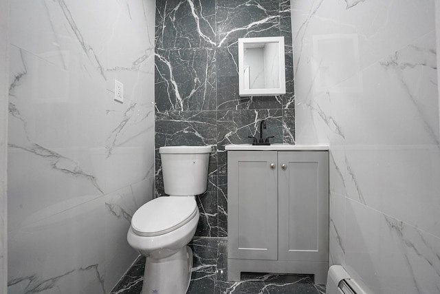 bathroom featuring vanity, a baseboard heating unit, and toilet