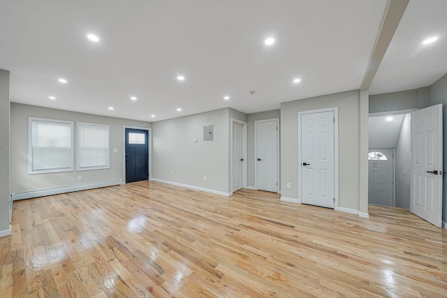 unfurnished living room with a baseboard radiator and light hardwood / wood-style floors