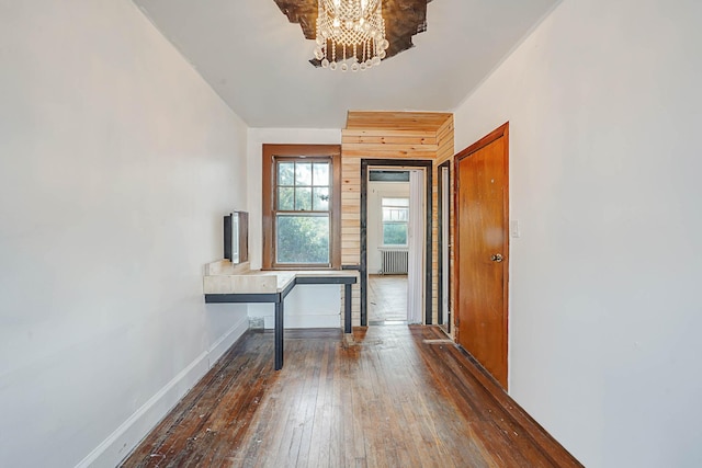 entrance foyer featuring a notable chandelier, dark hardwood / wood-style floors, and radiator