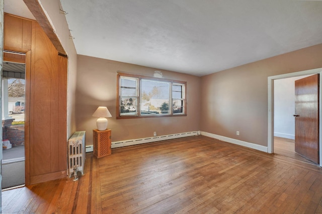 unfurnished room featuring a baseboard radiator and wood-type flooring